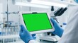 © PixelVision - Close-up Scientist Hand with Tablet Green Screen Mockup Background
