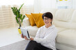 © satura_ - Woman sitting on carpet using tablet in cozy living room. Relaxed home computing, remote communication, and casual digital lifestyle indoors.