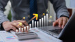 © Father_Studio - Businessman calculating financial interest with growth arrow, money and business investment analysis, profit increase, revenue planning and economic success concept.