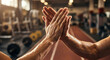 © silapin - Close up of two athletic men giving high five gesture after workout in gym. Sport teamwork concept. Slight motion blur