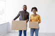 © Prostock-studio - Smiling millennial african american woman and man carry cardboard boxes with things in empty room. Moving to new home, positive emotions, real estate purchase and relocation. Mortgage, credit, loan