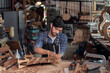 © surachetkhamsuk - Luthier creating a guitar, clamps on the body of a guitar under construction improving glue adhesion.