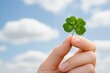 © MarisaSp - St.Patrick's Day lucky four-leaf clover held in hand against blue sky with copy space