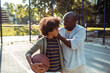 © Davor - Senior grandfather and child grandson smiling with basketball at outdoor court