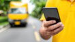 © Chaiwit - Digital literacy intelligence future innovation technology mobile phone hand outdoor communication connection screen focus yellow shirt delivery