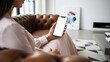 © MD Rashedul Islam - Hand holding mobile phone with blank white mockup screen by woman sitting on luxury leather sofa in modern minimalist interior for professional app showcase and branding design.