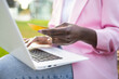 © ADDICTIVE STOCK - Confident female CEO with credit card using laptop