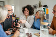 © Halfpoint - Tutor teaching seniors about phone scams and digital safety.