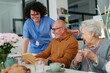 © Halfpoint - Group of senior people enjoying different activities in community center.