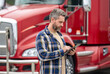 © be free - Service diagnostics for truck. Man use tablet to configure equipment. Automated logistics online internet. Trucker driver man with tablet control loading cargo. Truck maintenance. Hispanic trucker