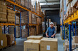 © Halfpoint - Older male warehouse worker pulling a pallet truck.