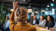 © Laura - Faceless woman raising hand in corporate meeting with audience, participation gesture, professional engagement scene, with copy space