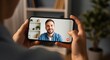© ANDREY PROFOTO - Hands holding smartphone for a video call with a smiling man