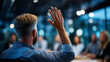 © Laura - Faceless audience member raising hand during corporate presentation in modern conference room, participation gesture, with copy space