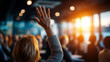 © Laura - Faceless audience member raising hand during conference Q&A in bright room, participation gesture, question asking moment, with copy space