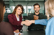© Stock 4 You - Group of corporate people happy with results of team work at meeting. Mature Latin bank worker woman shaking hand with client, recruit employee or business partner after signing collaboration contract