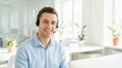 © CK Studio - A smiling young man wearing a headset provides professional customer service in a bright, modern office, looking at the camera.