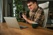 © Miljan Živković - Young man using smart phone while working from home