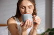 © New Africa - Beautiful woman with cup of aromatic coffee at home