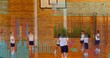 © vectorfusionart - Coaching teacher guiding seven kids in white tees navy shorts at school gym, with tablet chart