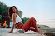 © we.bond.creations - Young woman smiling, relaxing outdoors during summer travel. She is experiencing freedom and happiness on her vacation