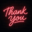 © BuatBikin - Neon sign displaying a thank you message against a dark brick wall background