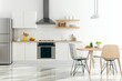 © Alena - Minimalist kitchen setup featuring clean lines and natural materials, showcasing a well-organized space after holiday meals with ample copy space
