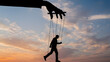 © Eggie - Silhouette of a large hand controlling a human puppet with strings against a dramatic sunset sky, symbolizing manipulation and lack of freedom.