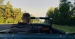 © m-art - Rear view of an anonymous man as he pulls off the curb onto the highway and starts driving outside the city