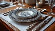 © Zarmeena - A detailed close-up of an ornate plate resting atop a crisp white place mat, surrounded by elegant cutlery on a charming wooden table.