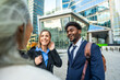 © unai - Diverse business professionals having cheerful conversation outdoors in city