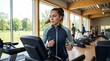 © crispy - Young woman running on a treadmill in a fitness gym. Healthy lifestyle and workout concept. Cardio exercise and athletic training