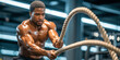 © FATNA - Portrait of a black muscular man doing battle rope workout at gym. Healthy lifestyle, fitness and motivation concept.