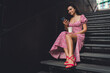 © BullRun - Smiling Hispanic woman in floral dress sits on stairs with smartphone and coffee cup, representing relaxation, digital lifestyle, and freelance flexibility in modern connected world.