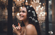 © BullRun - Side portrait of Hispanic woman with curly hair decorated with small flowers, smiling with dreamy look, symbolizing creativity, femininity, and empowerment in lifestyle photography.