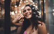 © BullRun - Smiling Hispanic woman with curly hair and white flowers, looking upward joyfully, expressing freedom, positivity, and empowerment in contemporary lifestyle portrait photography.