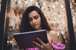 © BullRun - Serious young Hispanic woman with curly hair holding tablet in hands, concentrating on screen, symbolizing professional focus, freelance career, and modern digital independence.