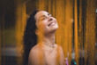 © BullRun - Close-up of smiling Hispanic woman with curly hair outdoors among golden chains, symbolizing joy, individuality, and empowerment in modern connected lifestyle imagery.