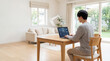 © Bmusic - Person working remotely on laptop with AI interface at home