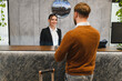 © Serhii - Hotel receptionist providing check in service to arriving guest