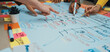 © InfiniteFlow - This image showcases a vibrant teamwork environment where diverse hands engage in a brainstorming session, utilizing sticky notes and markers on a whiteboard for strategic planning. SACTR