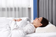 © New Africa - Young woman sleeping on bed with orthopedic pillow at home. Healthy posture