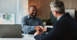 © BuyOutFelix06/peopleimages.com - Shaking hands, collaboration and business men in office for finance partnership, agreement or deal. Happy, meeting and male financial advisor with client for investment contract with handshake.