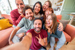 © Davide Angelini - Group of friends taking selfie with smart mobile phone device at home - Happy young people smiling together at camera - University students having fun together in college campus - Friendship concept