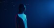 © m-art - A woman stands in the blue studio light with a serious look. She starts to catch soap bubbles falling from above with her finger