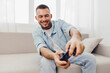 © SHOTPRIME STUDIO - Happy man enjoying a video game in a cozy home environment, representing the balance between leisure and technology. Embracing life’s imperfections and solo living.