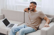 © SHOTPRIME STUDIO - Smiling man talking on the phone, dressed casually in a comfortable home setting, radiating positive energy and warmth. Ideal for lifestyle and communication themes.