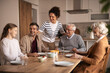 © Jelena - Happy multi-generational family having lunch at home