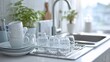© TANATPON - Clean modern kitchen sink with white cups and glassware in daylight