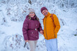 © kittyfly - Happy man and woman, walk by hand in beautiful winter park, senior couple in snowy forest, mature two people together, enjoying active retirement outdoors, love in coldest Christmas season snowy trees